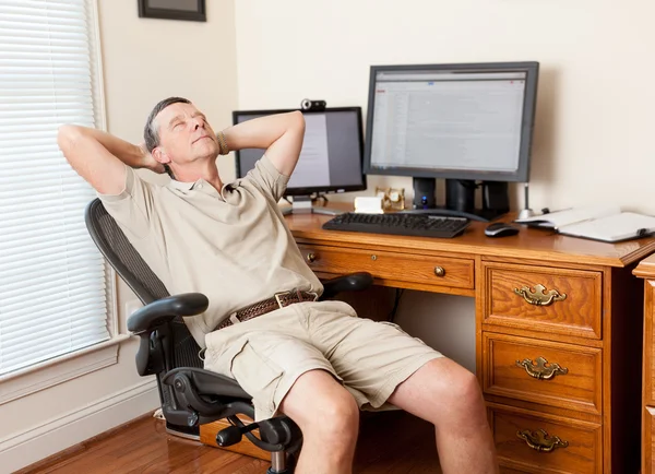 Senior man werken in kantoor aan huis — Stockfoto