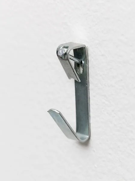 Macro of steel picture hook nailed to wall — Stock Photo, Image