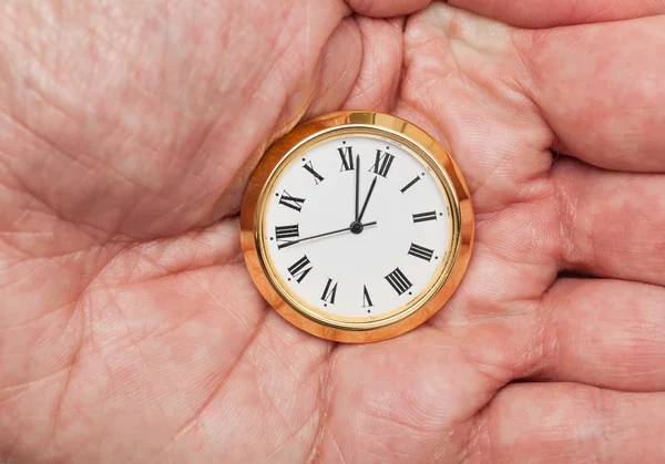 Brass small watch or clock in palm of hand — Stock Photo, Image