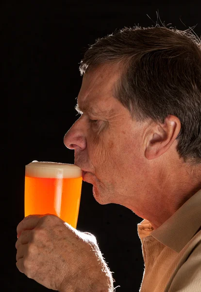 Homem sênior sorvendo de cerveja de copo de cerveja — Fotografia de Stock