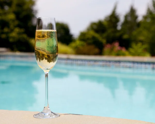 Flöjt kall champagne av sidan av pool — Stockfoto