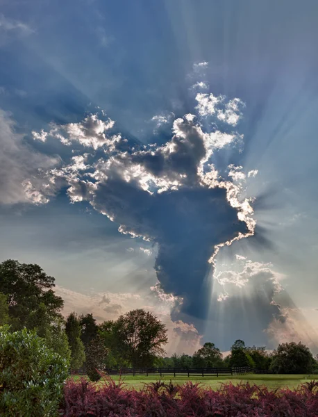 HDR image of a tall cloud with sunbeams — Stock Photo, Image