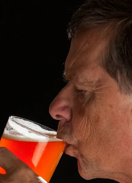 Starszy człowiek, popijając z szkła kufel piwa — Zdjęcie stockowe