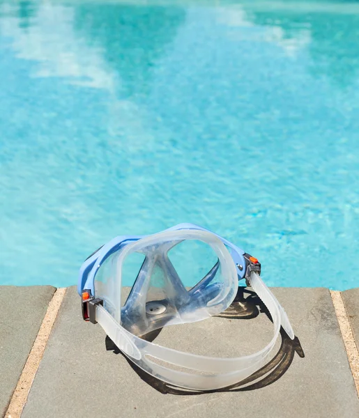 Плавательная маска у синего бассейна — стоковое фото