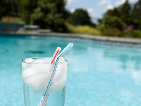 Ποτήρι νερό με παγάκια στην πλευρά της πισίνας — Φωτογραφία Αρχείου