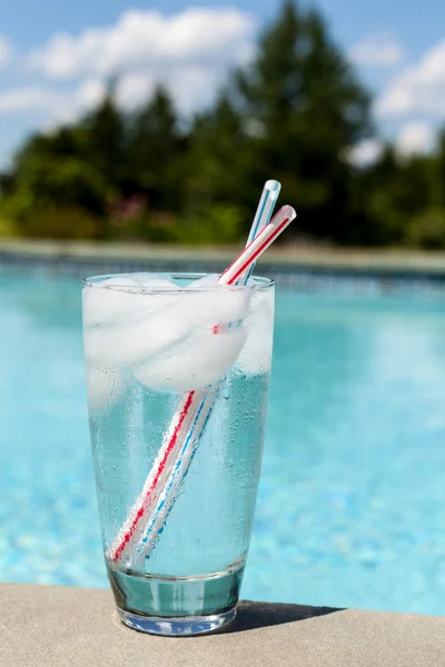 Vaso de agua con cubitos de hielo a un lado de la piscina — Foto de Stock