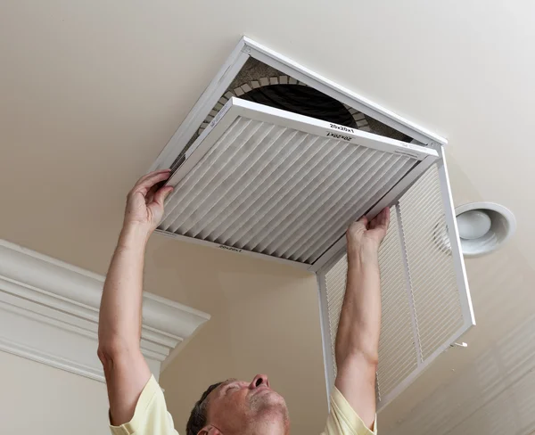 Senior homem abrir filtro de ar condicionado no teto — Fotografia de Stock