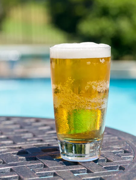 プールサイドでのテーブルの上のビールのグラス — ストック写真