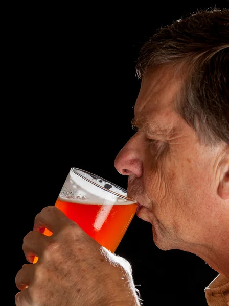 Hombre mayor bebiendo cerveza de vidrio de cerveza — Foto de Stock