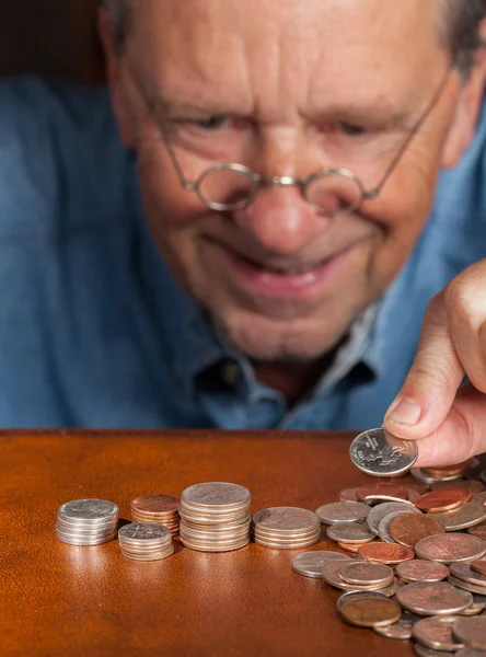 Äldre man räkna kontanter i högar — Stockfoto