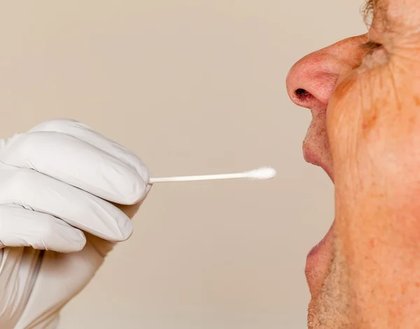 Un hisopo de ADN de saliva tomado de un hombre mayor —  Fotos de Stock