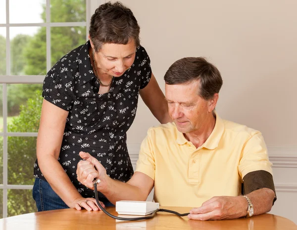 Hombre mayor tomando presión arterial con su esposa — Foto de Stock