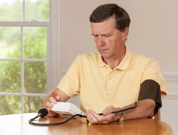 Senior man nemen bloeddruk thuis — Stockfoto