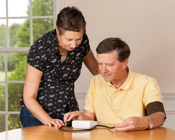 Hombre mayor tomando presión arterial con su esposa — Foto de Stock