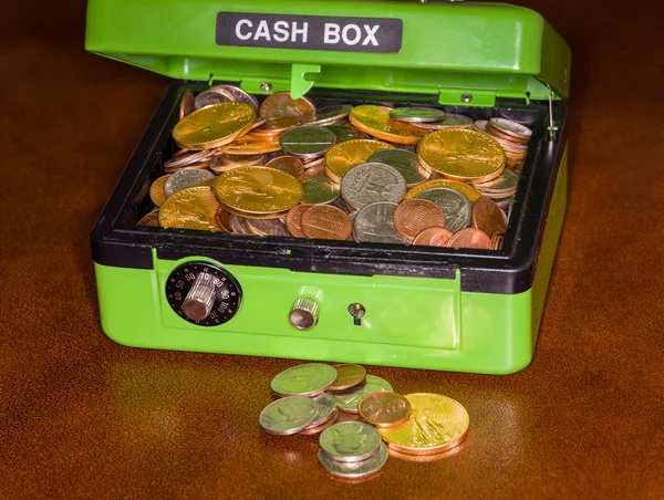 Зелена касова коробка з золотими та срібними монетами — стокове фото