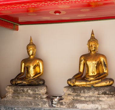 Pair of buddha statues in Wat Po temple clipart