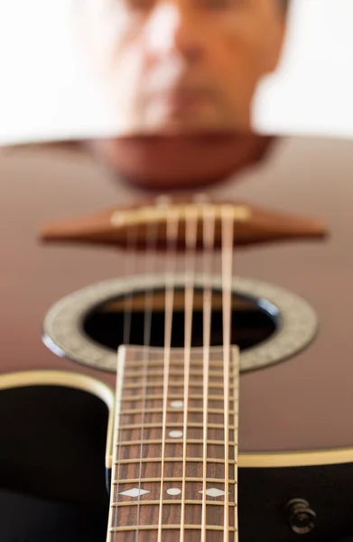 View down the fretboard of guitar to face — Stock Photo, Image