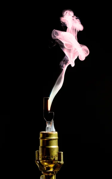Broken lightbulb flares up in smoke — Stock Photo, Image