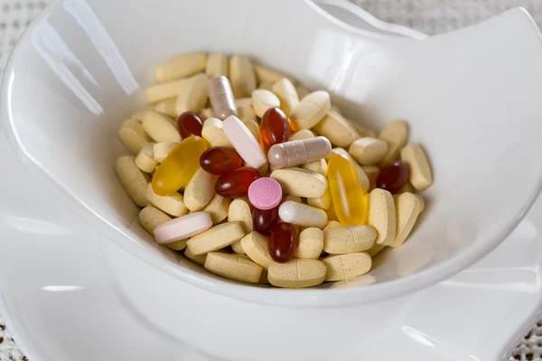 Vitamins in bowl of tablets — Stock Photo, Image