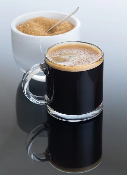 Café preto e espuma em caneca de vidro com açúcar — Fotografia de Stock