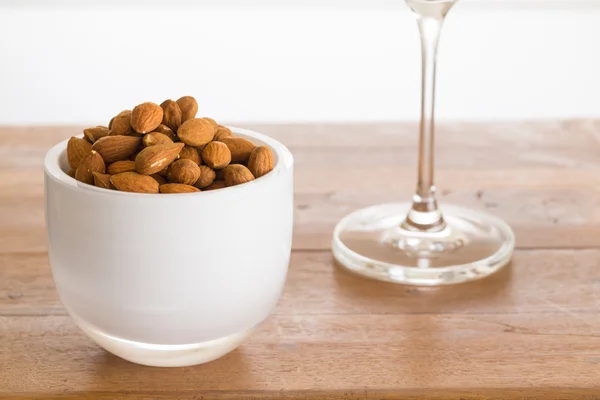 Mangkuk kacang almond mentah di atas meja kayu — Stok Foto