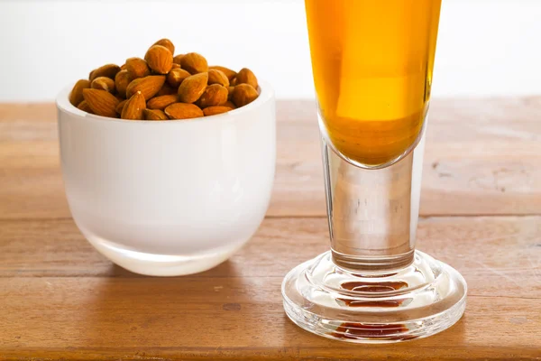 Miska syrové mandlové ořechy na dřevěný stůl — Stock fotografie
