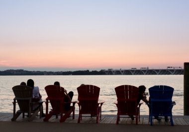 Tourists watch sunset from National Harbor clipart
