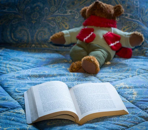 在床上的玩具熊与开放的平装书 — 图库照片