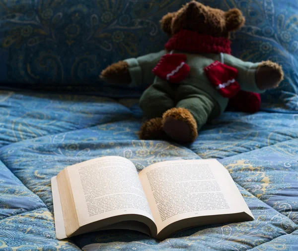 Taschenbuch offen im Bett mit Teddybär — Stockfoto
