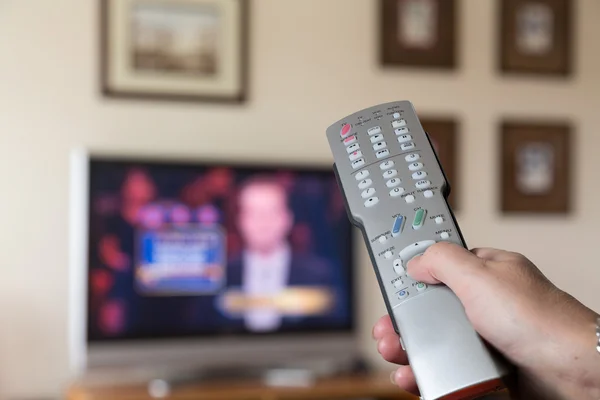 Silver remote control for TV with screen in back — Stock Photo, Image
