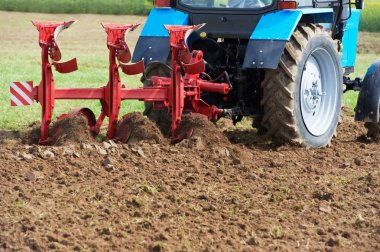 Ploughing tractor at field cultivation work clipart