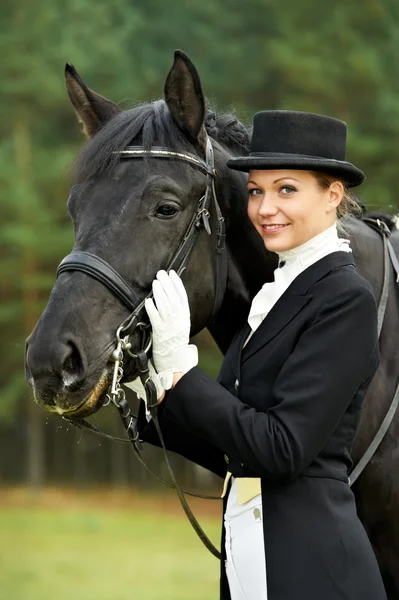 Jezdkyně žokej v uniformě s koněm — Stock fotografie