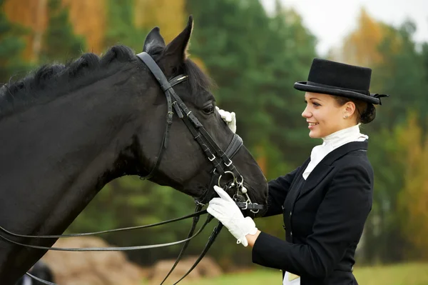 Ryttarinna jockey i uniform med häst — Stockfoto