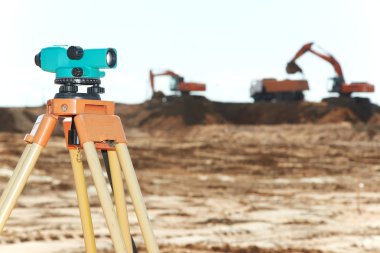 Surveyor equipment level at construction site clipart