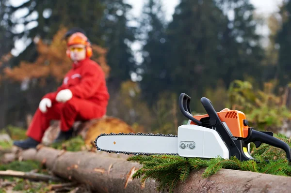 Lumberjack trabalhador com motosserra na floresta — Fotografia de Stock