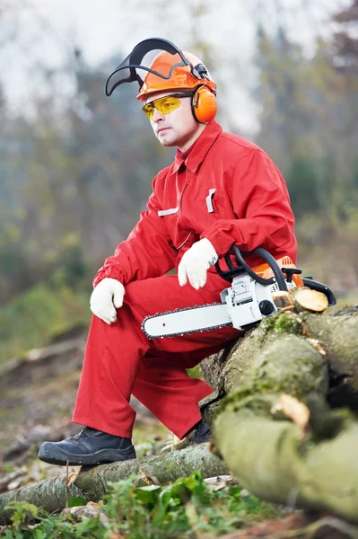 Pilarz pracownik z piłą łańcuchową w lesie — Zdjęcie stockowe