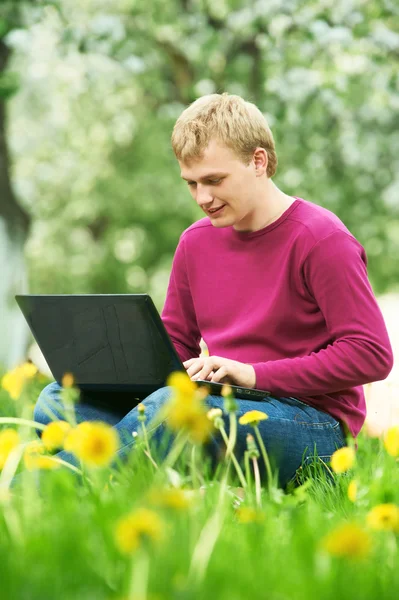 Mladý student venku s počítačem — Stock fotografie