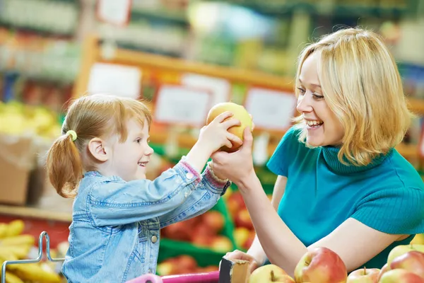 Kvinna och liten flicka shopping frukter — Stockfoto