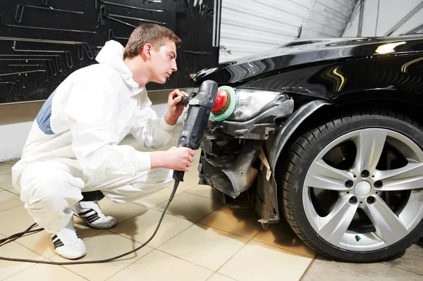 Mechanic repairing and polishing car headlight — Stock Photo, Image