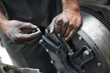 Auto mechanic hands at car repair work clipart
