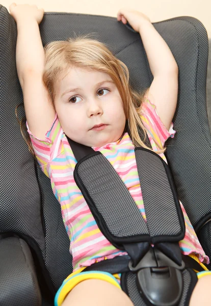 Small girl sitting in a car safety seat with seatbelt — Stock Photo, Image