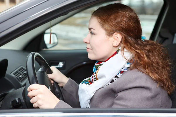 Bastante joven mujer caucásica manejando cuidadosamente un coche —  Fotos de Stock