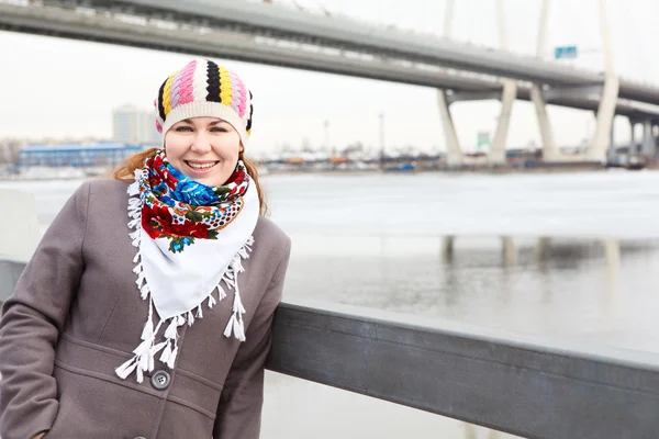 Ritratto di giovane donna caucasica felice con sciarpa in piedi su terrapieno. Copia spazio — Foto Stock
