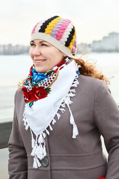 Close up portrait of happy young Caucasian female with scarf on neck. Standing outdoor — Stock Photo, Image