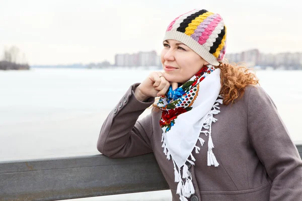 Portret van gelukkige jonge Kaukasische teef met sjaal staande op de dijk. kopie ruimte — Stockfoto