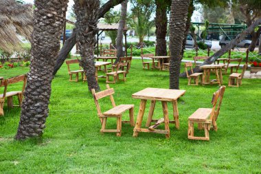 otel bölgesi ile ahşap masa ve banklar yeşil çimenlerin üzerinde