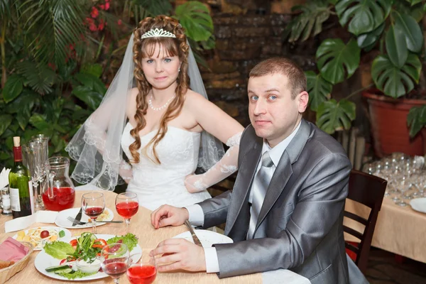 Нещодавно одружена пара сидить за столом в ресторані, романтична весільна вечеря — стокове фото