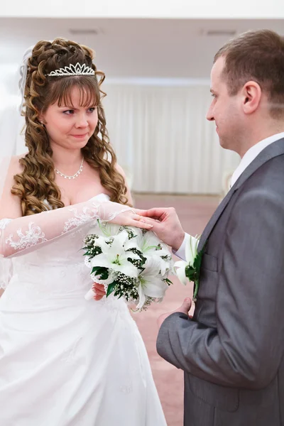 Marié met une bague de mariage sur le doigt des mariées — Photo