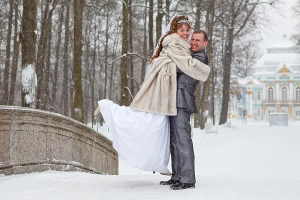 Unga bröllop kaukasiska ryska par embracing på snöig park. vintersäsongen i Ryssland — Stockfoto