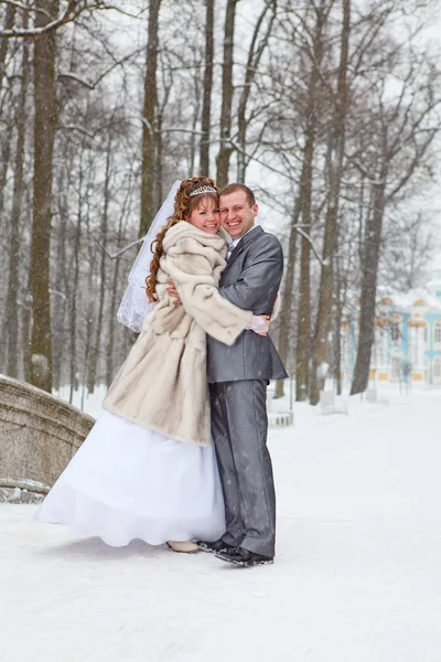 Молодая брачная русская пара, обнимающаяся в снежном парке. Зимний сезон в России — стоковое фото